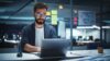 Berater mit Brille sitzt nachts im Office vor Laptop und arbeitet an Operational Excellence