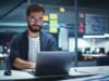 Berater mit Brille sitzt nachts im Office vor Laptop und arbeitet an Operational Excellence